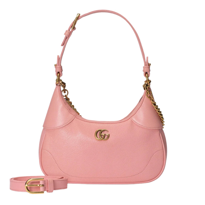 Pink handbag with gold accents on a light purple background